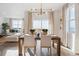Dining room with a modern light fixture, large windows, and views into the living room at 4316 Gypsum Ave, Mead, CO 80504