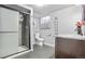 Well-lit bathroom featuring a glass door shower, toilet, vanity with granite counters, and gray tile flooring at 1376 S Zephyr Ct, Lakewood, CO 80232