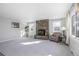 Bright living room featuring a stone fireplace, carpet floors, and large windows at 1376 S Zephyr Ct, Lakewood, CO 80232