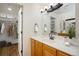 Bathroom featuring wood cabinets, a large mirror, and a doorway to a walk-in closet at 2120 Gross Dam Rd, Golden, CO 80403