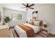 Bright bedroom featuring a ceiling fan, a large window, and neutral decor at 2120 Gross Dam Rd, Golden, CO 80403