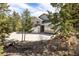 Two-story home with a two-car garage and beautiful landscaping, nestled among tall pine trees at 2120 Gross Dam Rd, Golden, CO 80403