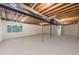 Unfinished basement with exposed ceiling beams and a window letting in natural light at 34586 Morgan Trl, Elizabeth, CO 80107