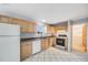 Cozy kitchen featuring classic wood cabinets, white appliances, and durable tile flooring at 34586 Morgan Trl, Elizabeth, CO 80107