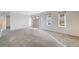 Open living room with neutral carpet, large windows, and a front entryway at 34586 Morgan Trl, Elizabeth, CO 80107