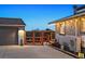 Charming home featuring a detached garage and an orange-railed deck, enhanced by string lights and unique architectural details at 812 Aspen Rd, Golden, CO 80401
