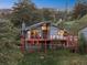 Inviting two-story home featuring a spacious deck with views of the surrounding trees and landscape at 812 Aspen Rd, Golden, CO 80401