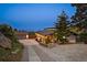 Beautiful home with a driveway, landscaping, and a detached garage, illuminated by warm exterior lighting at twilight at 812 Aspen Rd, Golden, CO 80401