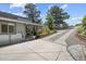 View of a concrete driveway and covered porch with seating beside landscaped flower beds at 812 Aspen Rd, Golden, CO 80401