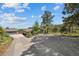 Wide driveway and gravel area outside a charming home with mature trees and a detached garage at 812 Aspen Rd, Golden, CO 80401