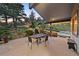 Beautiful outdoor patio with a water feature, dining table and chairs, surrounded by lush landscaping and mature trees at 812 Aspen Rd, Golden, CO 80401
