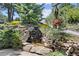 Charming stone water feature with lush plants and a hanging basket adding natural beauty to the outdoor space at 812 Aspen Rd, Golden, CO 80401