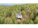 Stunning aerial view of modern home, complete with a spacious deck, nestled amongst towering green trees at 13910 Blue Jay Ln, Larkspur, CO 80118