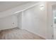 Bright attic room featuring a skylight, plank floors and neutral decor with white trim and door at 13910 Blue Jay Ln, Larkspur, CO 80118
