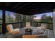 Enjoy this covered balcony with stylish seating and a fire pit with treetop and mountain views at 13910 Blue Jay Ln, Larkspur, CO 80118