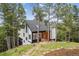 Charming exterior of a multi-level home surrounded by trees with a sloped yard and modern finishes at 13910 Blue Jay Ln, Larkspur, CO 80118