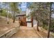 The exterior of this home features a wood and painted facade and a spacious drive up garage at 13910 Blue Jay Ln, Larkspur, CO 80118