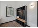Charming mudroom features a built-in bench with storage, coat hooks, and a window for natural light at 13910 Blue Jay Ln, Larkspur, CO 80118