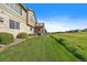 A well-maintained backyard with lush grass and a stone and siding exterior, backing onto community green space at 22023 E Heritage Pkwy, Aurora, CO 80016