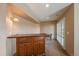 Basement bar featuring wooden cabinetry and a dark stone countertop with outside access at 22023 E Heritage Pkwy, Aurora, CO 80016