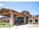 Clubhouse entrance featuring architectural timbers, glass doors, and attractive landscaping for a welcoming presence at 22023 E Heritage Pkwy, Aurora, CO 80016