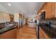 Well lit kitchen with stainless steel appliances, wooden cabinetry, and dark countertops at 22023 E Heritage Pkwy, Aurora, CO 80016