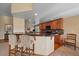 Stylish kitchen features granite countertops, wooden cabinetry, bar seating, and modern appliances at 22023 E Heritage Pkwy, Aurora, CO 80016