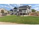 Inviting backyard with a deck, stone fire pit and lush green lawn, perfect for outdoor entertaining at 5181 Appleton Way, Castle Rock, CO 80104
