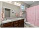 Bathroom featuring double sinks with granite counters, a shower with a pink curtain, and ample lighting at 5181 Appleton Way, Castle Rock, CO 80104