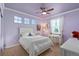 Charming bedroom featuring a white bed frame, a ceiling fan, and soft purple walls at 5181 Appleton Way, Castle Rock, CO 80104