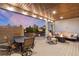 Relaxing covered deck with a fire table, comfortable seating, dining table and barbecue grill at 5181 Appleton Way, Castle Rock, CO 80104