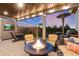 Relaxing covered deck with a fire table, comfortable seating, TV, dining table and barbecue grill at 5181 Appleton Way, Castle Rock, CO 80104