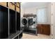 Laundry room featuring side-by-side stainless steel washer and dryer, built-in storage and tile flooring at 5181 Appleton Way, Castle Rock, CO 80104