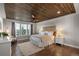 This spacious bedroom with a decorative wood ceiling has bright windows and hardwood floors at 5181 Appleton Way, Castle Rock, CO 80104
