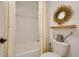 Cozy bathroom featuring a shower-tub combo with stylish curtains and a unique decor wreath at 8137 Ralston Creek Ave, Littleton, CO 80125