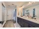 Bathroom with double vanity, modern fixtures, and a view of the glass shower at 8137 Ralston Creek Ave, Littleton, CO 80125