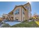 A multi-story home features a walk out patio, a backyard deck, and a manicured lawn at 8137 Ralston Creek Ave, Littleton, CO 80125