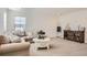 Bright living room featuring a comfortable sectional sofa and a stylish round coffee table, perfect for relaxing at 8137 Ralston Creek Ave, Littleton, CO 80125