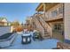 The patio features an outdoor seating set and a built-in firepit, with stairs up to the upper level deck at 8137 Ralston Creek Ave, Littleton, CO 80125