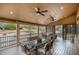 Outdoor dining space on a covered back porch with ceiling fans overlooking well maintained yard at 1479 Short Grass Ct, Castle Rock, CO 80109