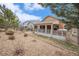 Backyard view shows a covered back porch with dining space, hot tub and well maintained yard at 1479 Short Grass Ct, Castle Rock, CO 80109