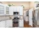 Well-lit kitchen features white cabinets, granite countertops, and stainless steel appliances at 1479 Short Grass Ct, Castle Rock, CO 80109