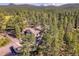 Aerial view of a private home nestled among lush green trees with mountain views in the distance at 5336 High Rd, Evergreen, CO 80439