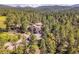 This aerial view shows a gorgeous residence nestled amongst a tranquil, wooded environment at 5336 High Rd, Evergreen, CO 80439