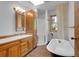 Bathroom with a skylight, vanity, tub and unique tile floor at 5336 High Rd, Evergreen, CO 80439