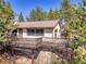The house's exterior features a wrap-around deck and lovely natural landscaping at 5336 High Rd, Evergreen, CO 80439