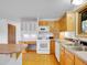 Bright eat-in kitchen with light-colored cabinets, wood floors, and white appliances at 5336 High Rd, Evergreen, CO 80439