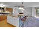 Kitchen with bar seating adjacent to a carpeted living space with white built-in shelves at 5336 High Rd, Evergreen, CO 80439
