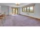 Spacious living room features neutral carpet, white walls, and multiple windows at 5336 High Rd, Evergreen, CO 80439