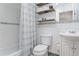 Cozy bathroom featuring decorative shelves, white tiling, and a shower with striped curtain at 10563 Pierson Cir, Broomfield, CO 80021